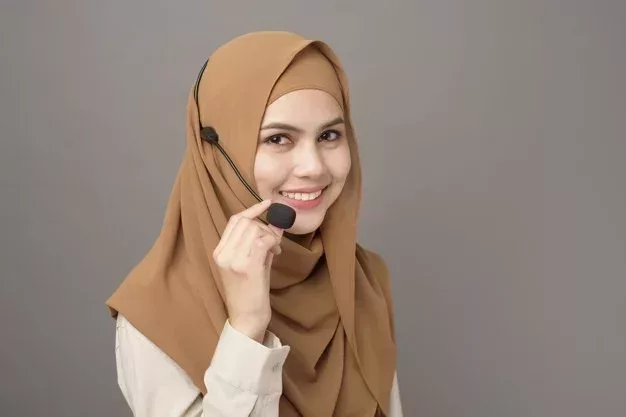 portrait of beautiful call center woman with hijab on gray background